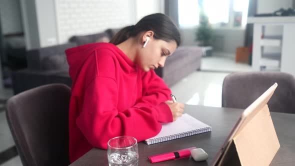 Beautiful Caucasian Female Student is Studying in College Remotely alt