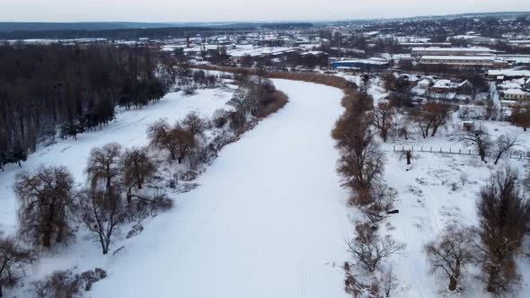 Aerial view on cold frozen wintery river in snow