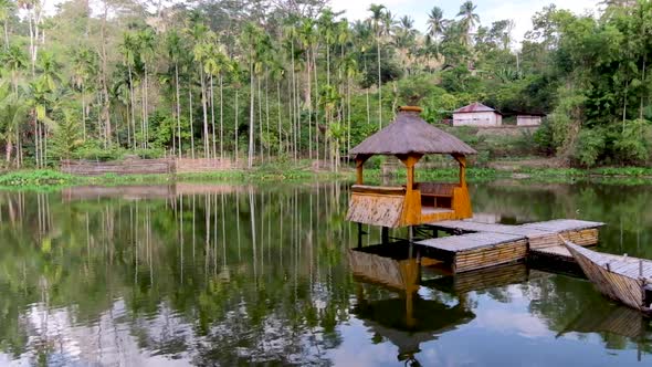 Idyllic bamboo hut pontoon with traditional thatched roof on the water surrounded by trees in Timor alt