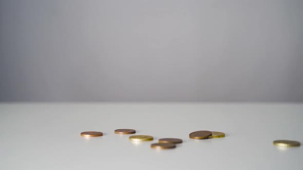 Euro Coins Falling on a White Table from Above in Slow Motion