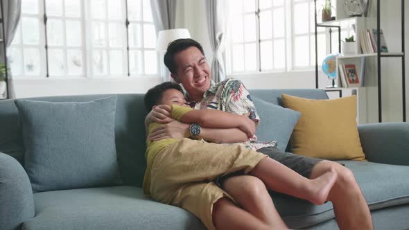 Asian Father And His Son Are Watching Scary Movie At Home alt