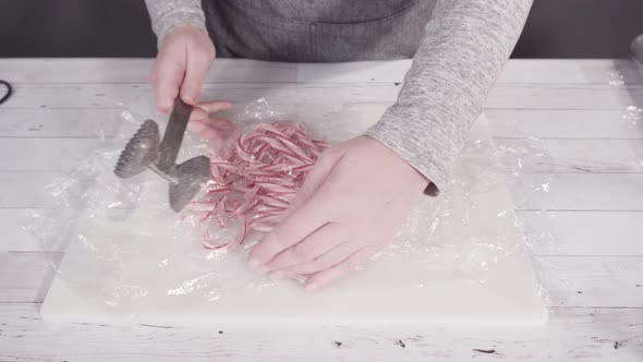 Step by step. Breaking candy cane candies into small pieces alt