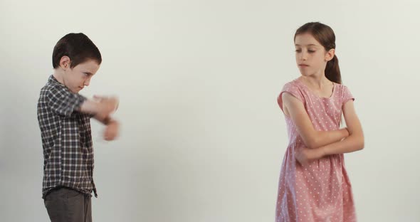 Brother and sister arguing and fighting on a white studio background alt