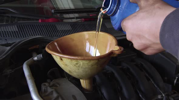 Pouring New Clean Synthetic Oil Into The Vehicle Engine alt