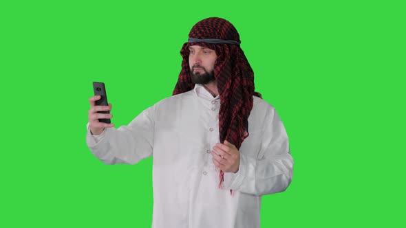 Arabian Man Walking and Making a Selfie with His Phone on a Green Screen, Chroma Key. alt