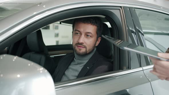 Car Dealership Client Getting Key Fob From Sales Manager Sitting Inside New Car alt