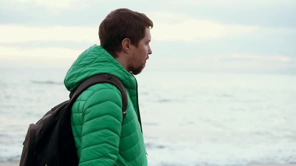 Man Is Near the Sea in a Cool Time, He Walks Along Street and Think About Life alt