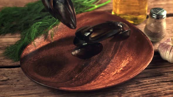 Super Slow Motion Boiled Mussels Fall Into a Wooden Plate alt