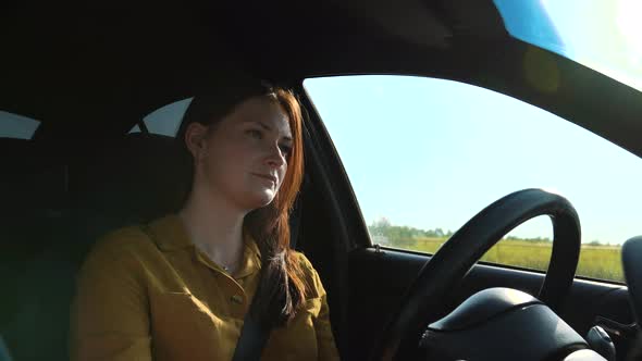 Woman Wearing Seat Belt is Driving in a Car Gazing Intently at the Road