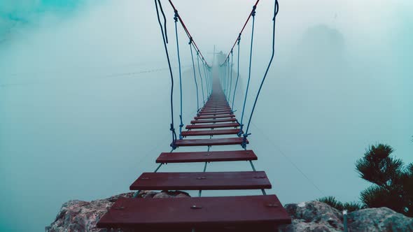 Timelapse high in the mountains. A hanging ladder in the gorge. Clouds and fog. staircase. alt
