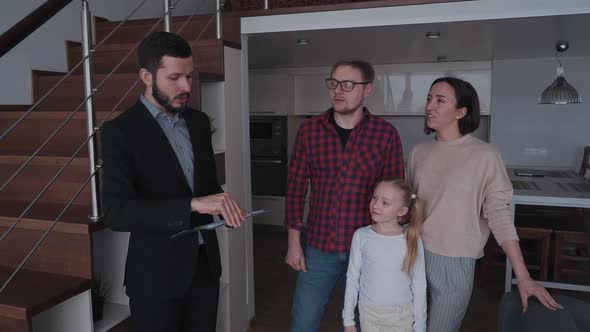 Realtor Man Showing New House To Happy Family of Three People alt
