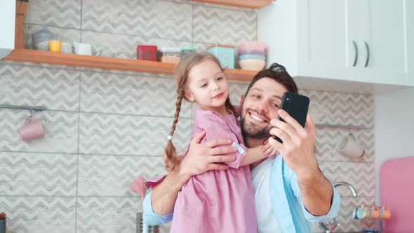 Smiling father and daughter taking selfie on smartphone. Dad and daughter spending time together alt