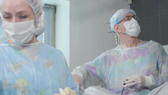 Medical Team Performing Surgical Operation in Bright Modern Operating Room alt