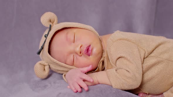 happy newborn baby weaing cute Mouse costume lying sleeps on a grey blanket comfortable alt