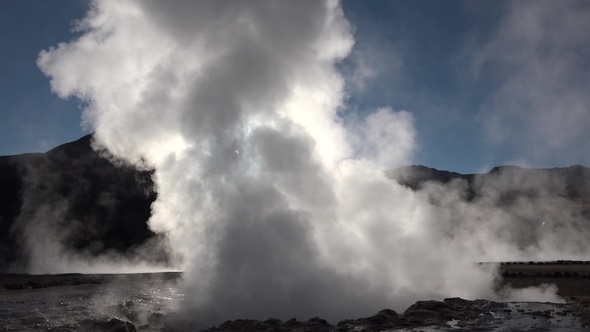 Boiling geysers with steam rising to the sky in Iceland. alt
