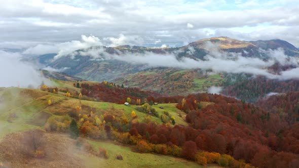 Fly Over Landscapes of Green Hills Under a Layer of White and Fluffy Clouds alt