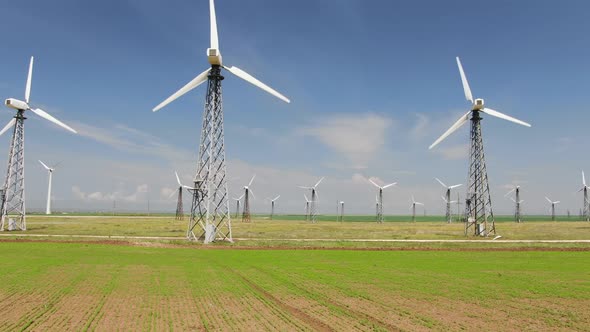 Row of Towers with Wind Turbines in Blue Sky Background alt