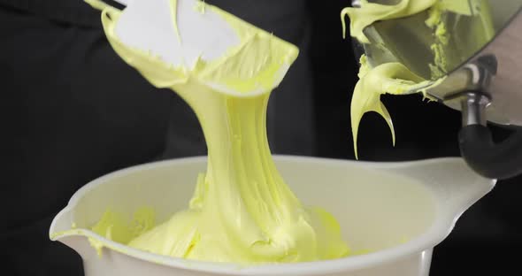 The Pastry Chef Puts the Whipped Butter or Butter Cream From the Mixer Into a Bowl