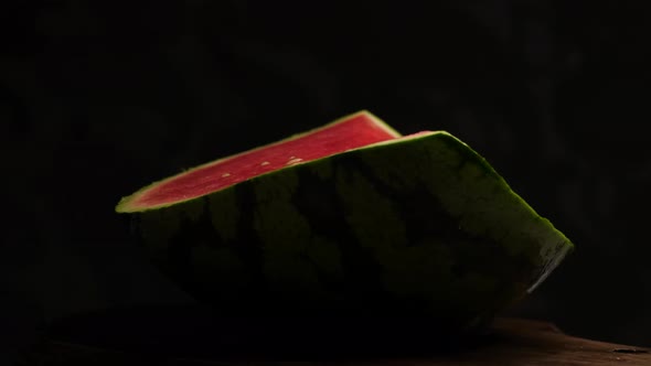 Delicious fresh quarters of watermelon rotates against a black background