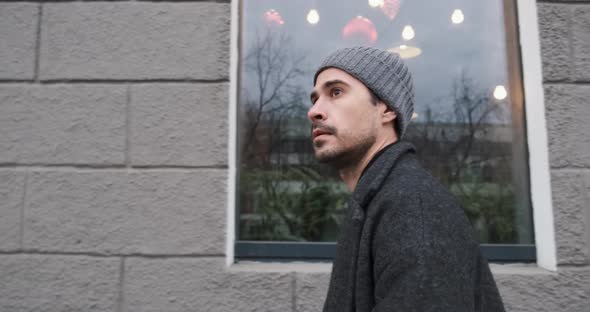 Modern Stylish Hipster Man is Walking in City with the Cup of Coffee