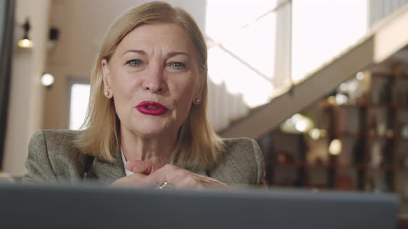 Senior Businesswoman Web Calling on Laptop in Restaurant alt