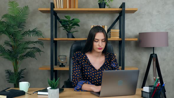 Beautiful brunette woman working at home office online uses laptop computer alt