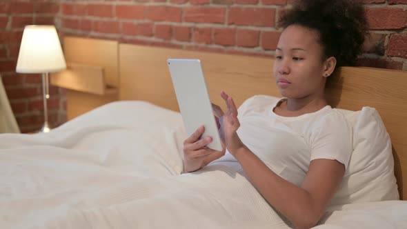 Young African Woman Using Tablet in Bed alt
