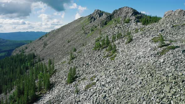 Aerial View, Drone Flies Along Steep Stone Slope of Mount with Stone Peaks