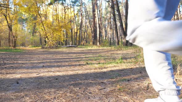 Unrecognizable Man Running Fast Along Forest Path at Sunny Day alt