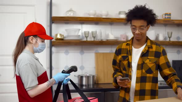 Happy African Man Taking Pizza From Courier and Paying with Nfc on Mobile Phone alt