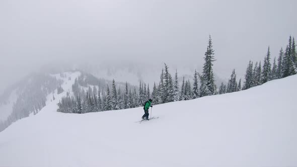Man Splitboarding Up Steep Slope Exploring Mountains In Winter Season alt