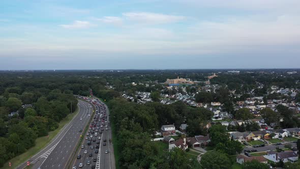 An high angle view next to a busy parkway in the evening, during rush hour. The camera boom down & t alt