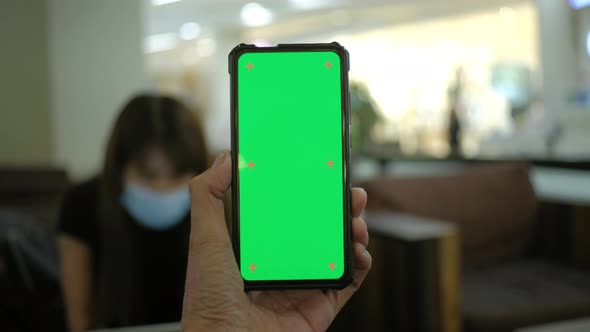 Man hand holding smart phone with chroma key green screen display, Handheld Camera.