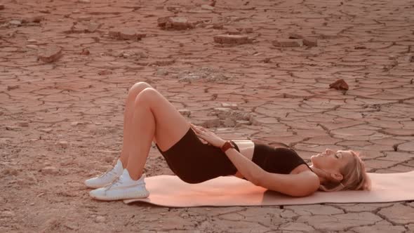 Sporty woman exercising on desert location