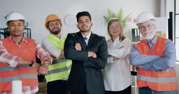 Team of Architects with Successful Bearded Main Architect which Posing on Camera with Crossed Arms alt