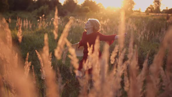 Portrait of Positive Smiling Woman Looking Into Camera at Sunset alt