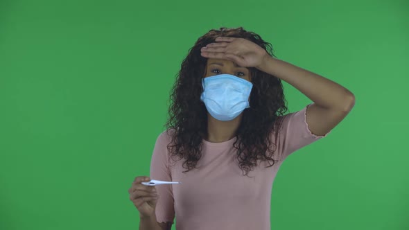 Portrait of Beautiful African American Young Woman in Medical Protective Face Mask Is Looking at alt