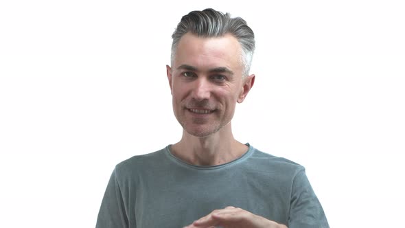 Middleaged Cheerful Man with Grey Hair and Bristle Waving Hand and Smiling Friendly Saying Hello alt