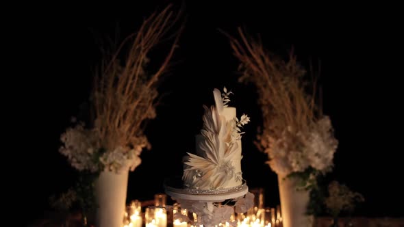 beautiful wedding cake near the wedding arch in the evening