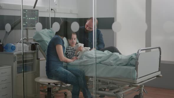 Worried Parents Sitting with Sick Girl Daughter Waiting for Sickness Expertise During Medical alt
