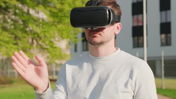Man Wearing Virtual Reality Headset and Manage the Interface in Augmented Reality alt