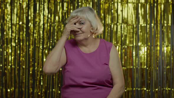 Portrait of Senior Old Woman with Closing Eyes with Hand and Spying Through Fingers, Hiding, Peeping alt