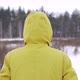 A man in a yellow jacket walks across a field in snowy weather - VideoHive Item for Sale