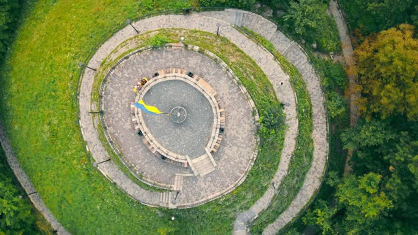 Aerial View on Top Woman Running on Top of a Mountain in the Park alt