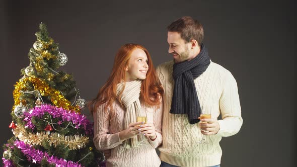 Beautiful Loving Couple Holding Champagne Glasses in Studio on Black Background alt