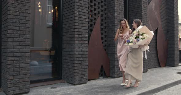 Elegant Women with Bouquets Posing in the City alt