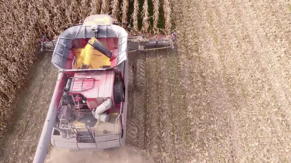 Close view of Combine Harvester in action, harvesting corn in the field in Southeast Michigan - aeri alt