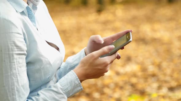 Girl with phone in park. Young woman speaking on mobile phone in park alt