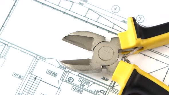 Cutting Pliers on Building Plan, Scheme, Rotation, Close Up alt