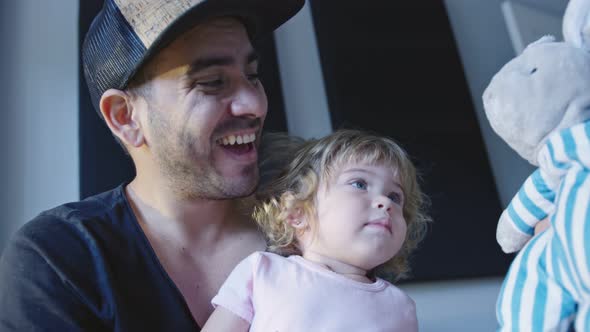 Happy Father Playing with Little Daughter and Stuffed Animal alt